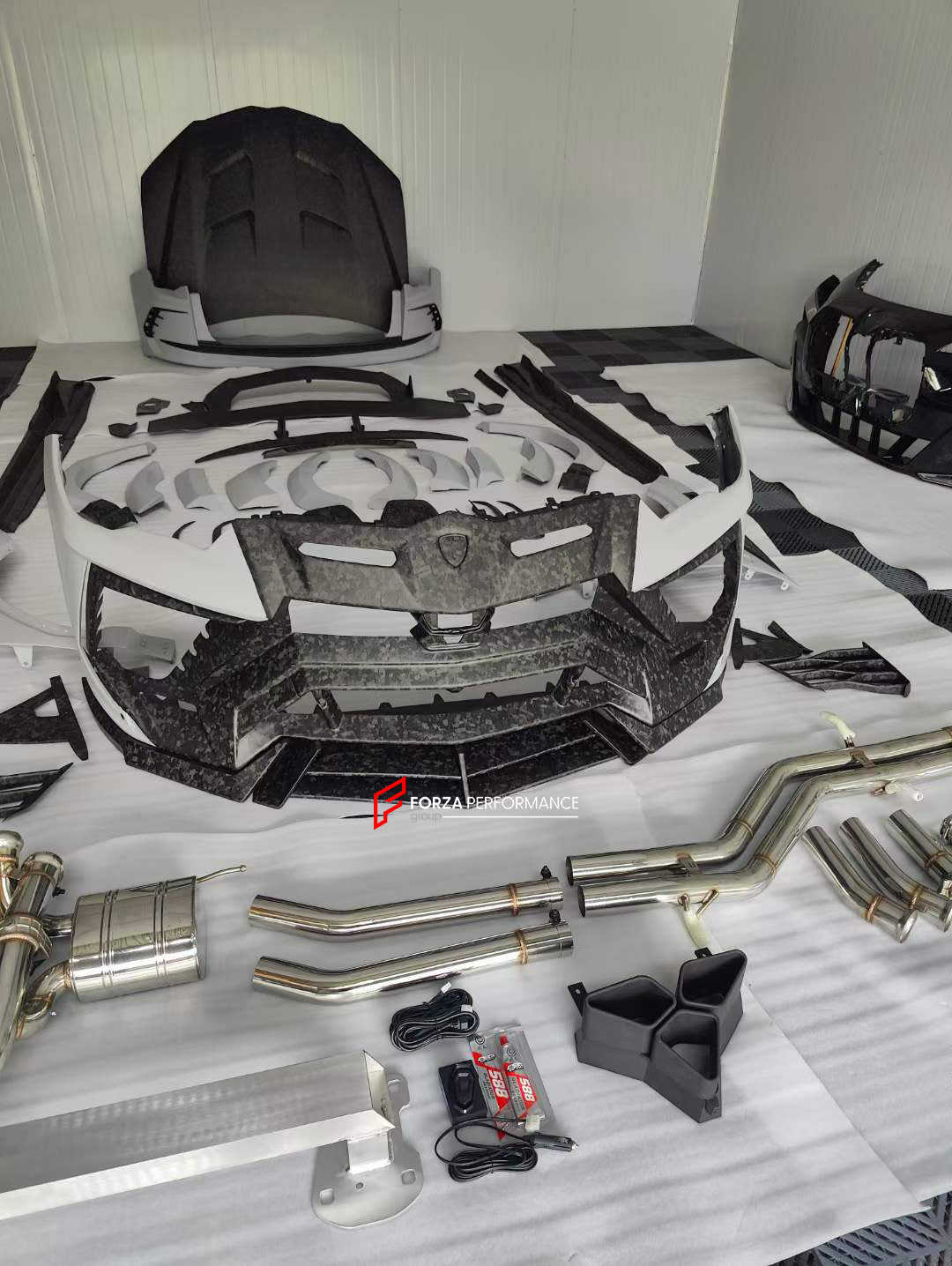 WIDE BODY KIT WITH EXHAUST CATBACK SYSTEM for LAMBORGHINI URUS 2018+  Set includes:  Front bumper Dry carbon front lip Dry carbon hood/bonnet Dry carbon front bumper eyebrows Front fenders Front fender flares Side skirts Dry carbon roof spoiler Dry carbon middle decklid spoiler Dry carbon trunk panel between tail lights Rear fender flares Rear bumper Dry carbon rear bumper side air vents Dry carbon rear diffuser Exhaust system with tips